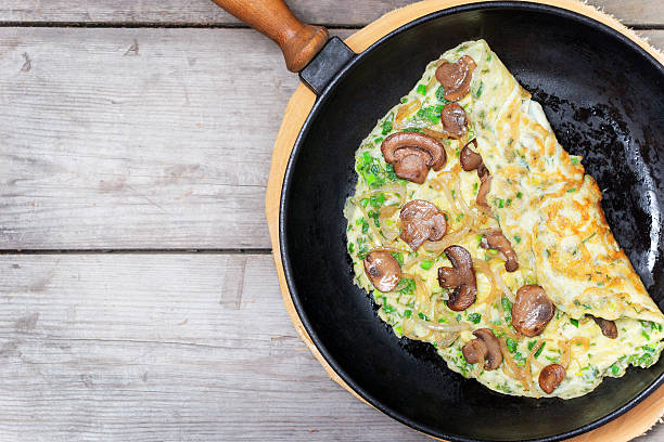 French omelet with herbs, stuffed with mushrooms and onions stock photo