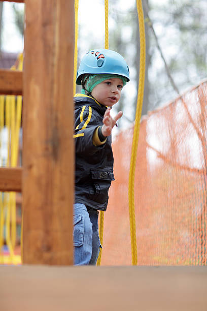 istock Child with helmet climbing on rope 520748398