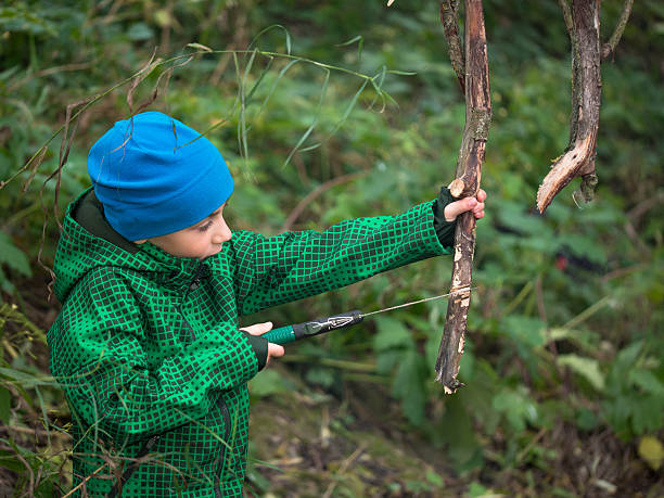 istock Little boy  handsaw sawing dry snag 520751581