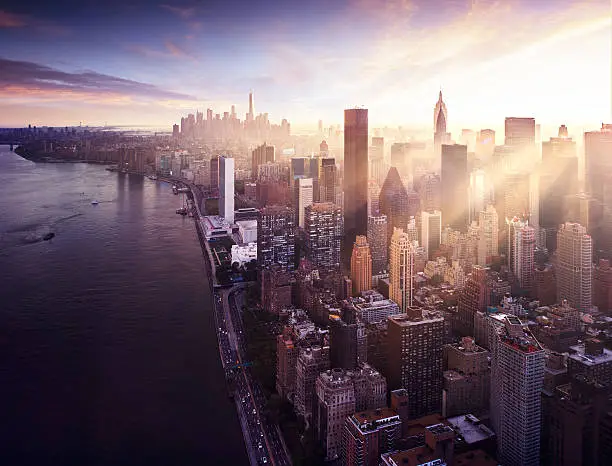 New York City - beautiful colorful sunset over manhattan with sunbeams between buildings