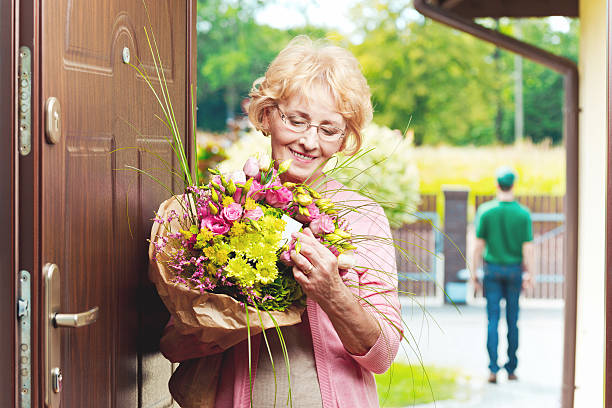 heureuse femme âgée recevoir des fleurs - mothers day flower gift bouquet photos et images de collection