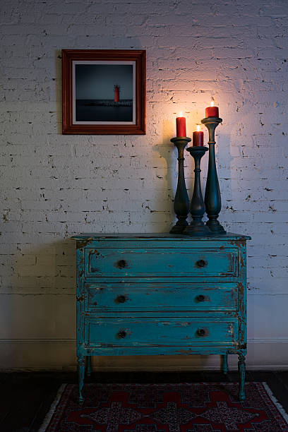 istock Green vintage cabinet, candlesticks and hanged painting on bricks wall 520767276