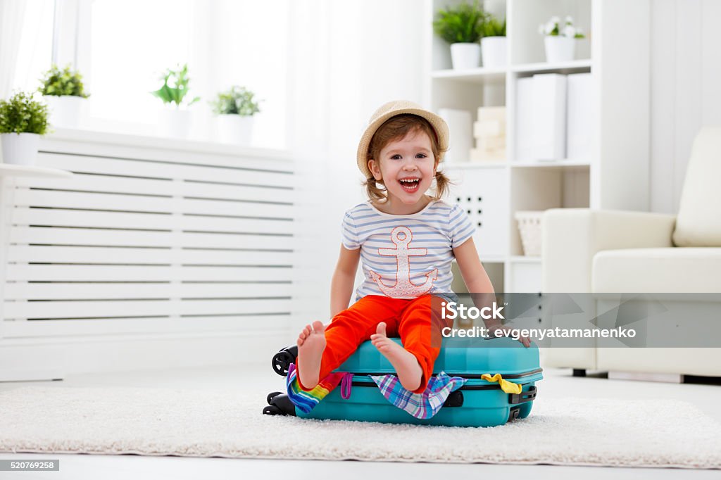 Glückliches Kind Mädchen-Pakete Kleidung in den Koffer für Reisen, Urlaubs - Lizenzfrei Beengt Stock-Foto