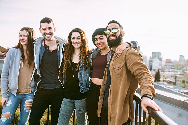 Multi ethnical group of friends standing on cliff together