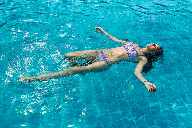 istock Attractive woman floating in the pool 520772099