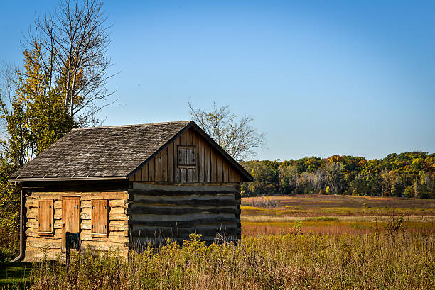 istock Old Log Cabin in Field with Blue Sky 520772595