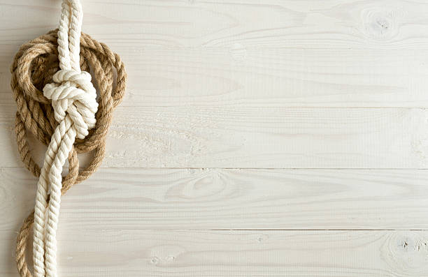 istock Toned image of ship ropes on wooden background 520774302