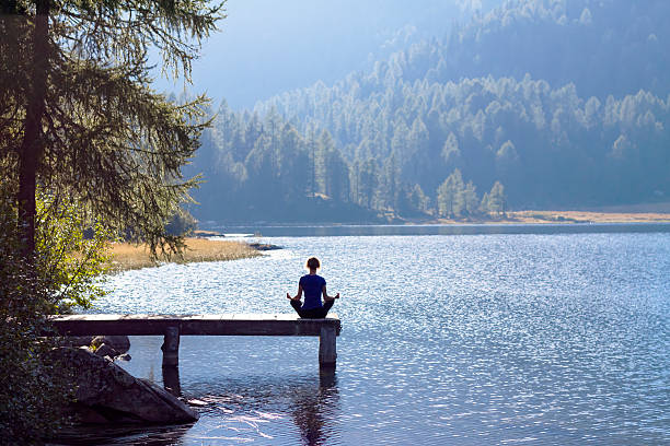 istock Woman doing yoga at lake 520774592