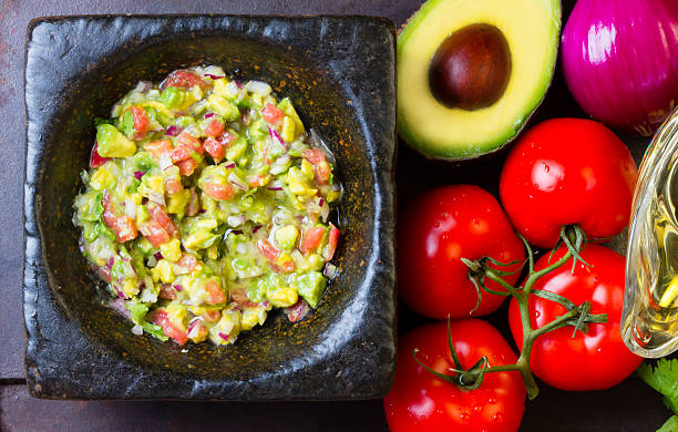 istock Guacamole in stone mortar and ingredients. Top view 520775086
