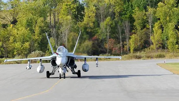 A colour image of a F-18A fighter jet taxing on the tarmac.