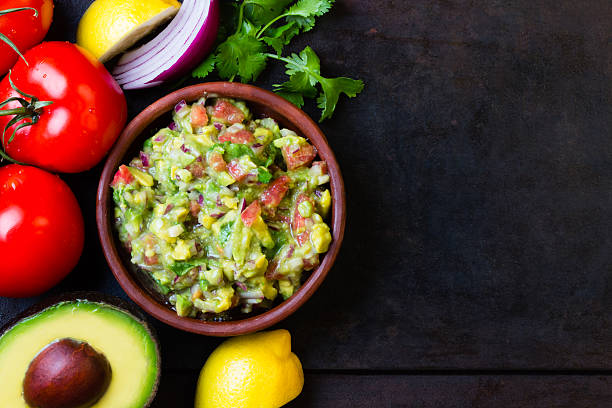 guacamole latinoamericana salsa mexicana en arcilla tazón de fuente y los ingredientes - avocado lemon snack cracker fotografías e imágenes de stock