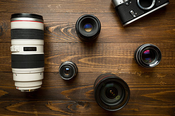 istock Vintage camera and different lenses lying on wooden background 520777538
