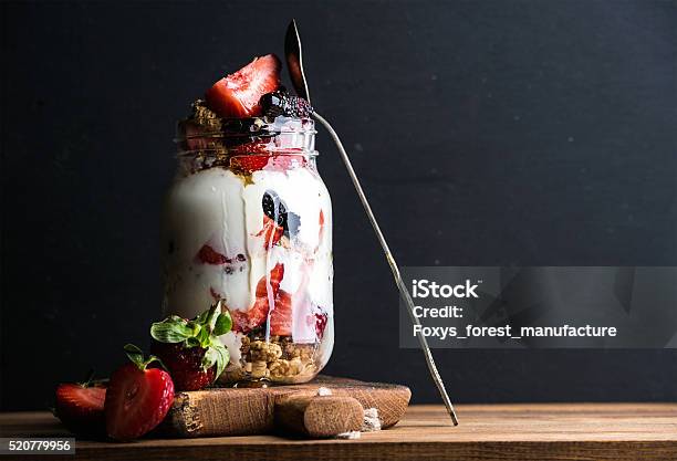 Yogurt Oat Granola With Strawberries Mulberries Honey And Mint Leaves Stock Photo - Download Image Now