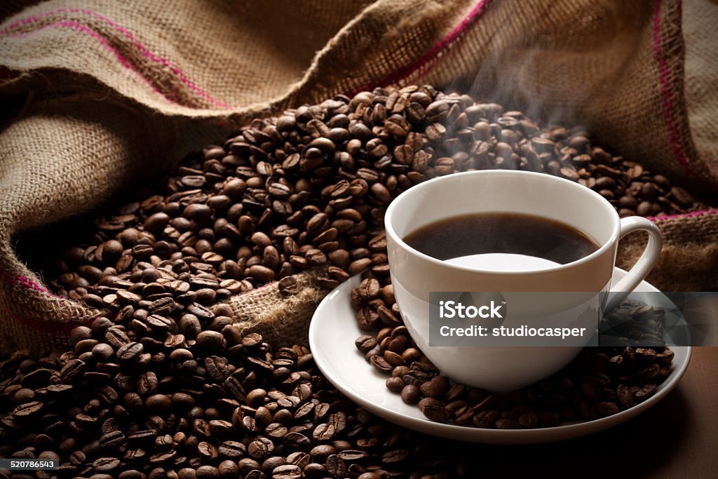 hot coffee cup of hot coffee on coffee beans Roasted Coffee Bean Stock Photo
