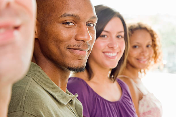 istock Two Men and Two Women Standing in a Row Smiling 520790637