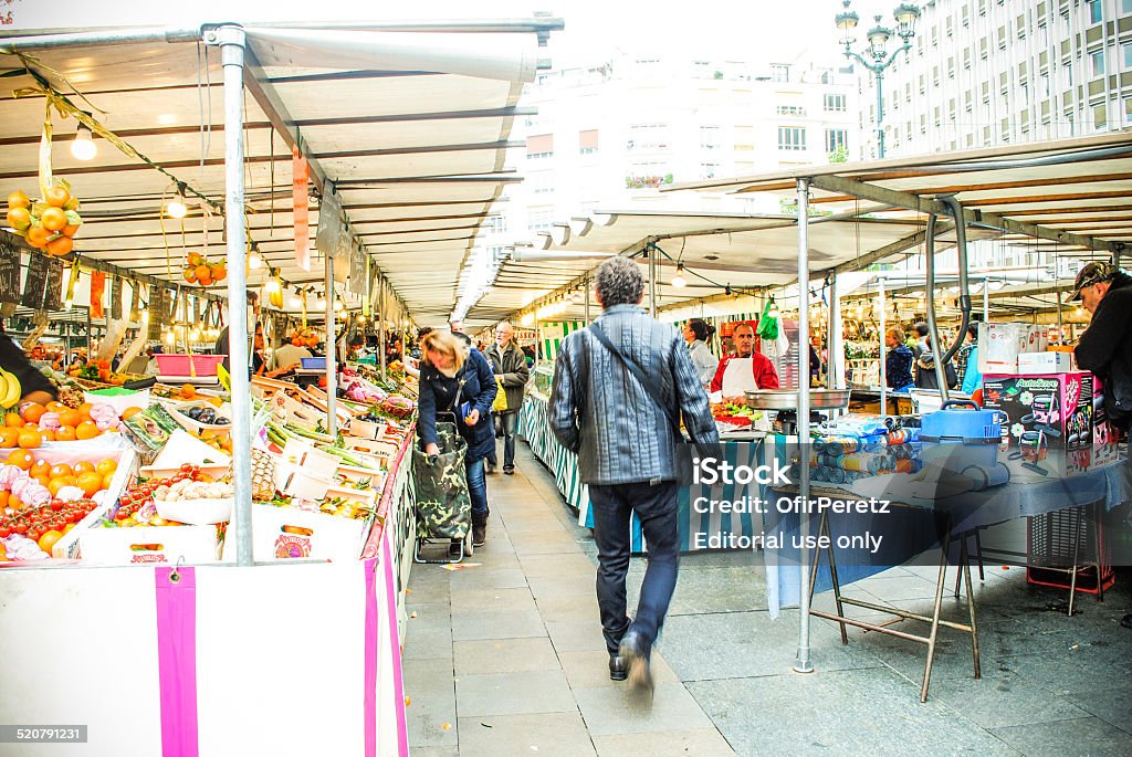 Street market in Paris. People walking and buying food Paris, France - October 26, 2014: market in Paris, France. People walking and buying food. Huge variety of fruits, vegetables and spices. Colourful organic and healthy products. . Adult Stock Photo