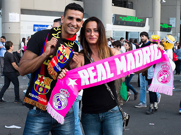 Young copule supporting Real Madrid and Barcelona stock photo