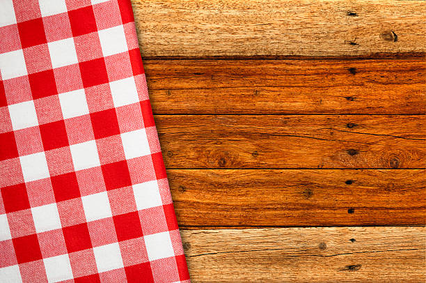 istock Red Checked Napkin on Rustic Wooden Picnic Table 520791794