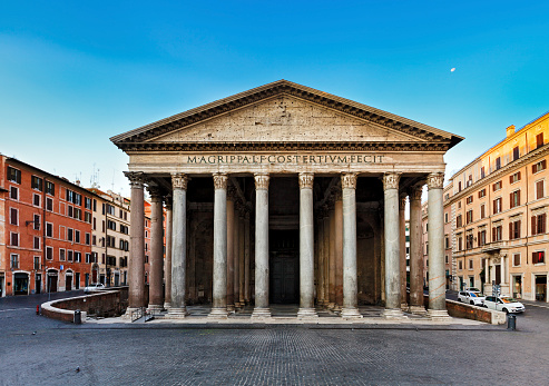 Italy Europe ancient roman pantheon temple front view at classical columns portic colonnade with surrounding historic rome buildings at sunrise nobody