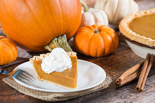 istock Slice of a pumpkin pie and pumpkins on the background 520792909