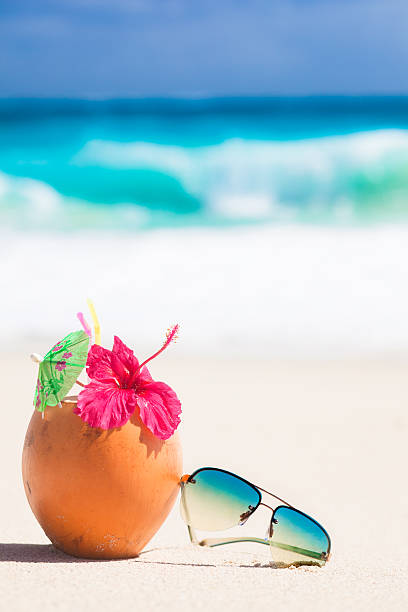 picture of fresh coconut juice and sunglasses at tropical beach