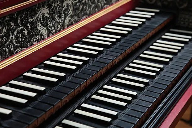 Old antique, historic, two rowed piano keyboard and beautiful ornaments on its forehead.