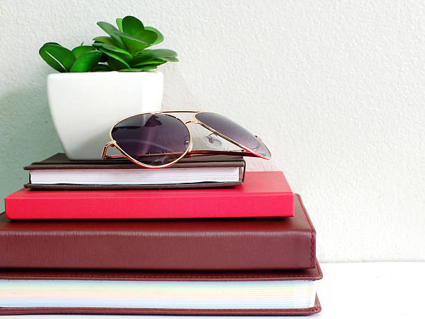 istock stack of notebook with artificial of plant and sunglasses 520798858