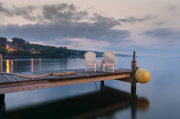 Idyllic Lake Seneca Two chairs sitting on a jetty at dusk, form a tranquil and idyllic scene at Lake Seneca, a popular vacation destination and located in the famous Finger Lakes region in New YorkState. finger lakes stock pictures, royalty-free photos & images