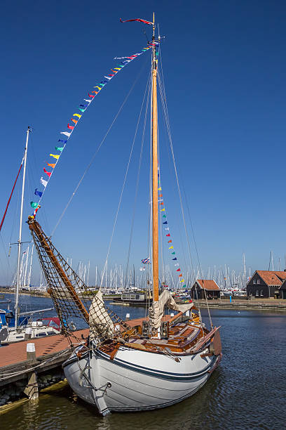 Decorated traditional sailing ship in the harbor from Harlingen in the Netherlands at sunset