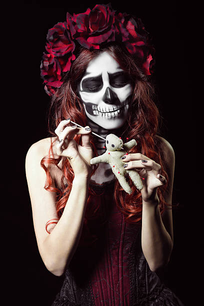 istock Young woman with calavera makeup (sugar skull) piercing voodoo doll 520804365