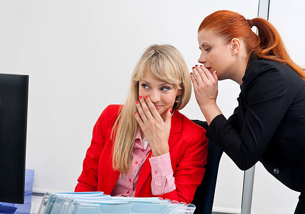 istock two woman colegues gossip in office 520805459
