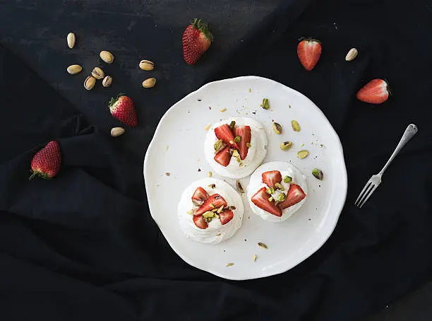 Photo of Small strawberry and pistachio pavlova meringue cakes with mascarpone cream