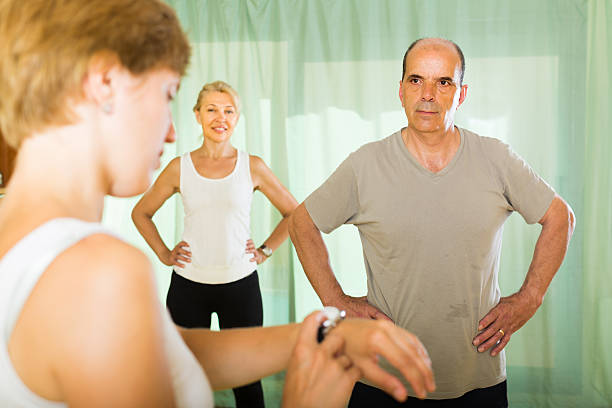 istock Mature couple with trainer at gym 520807373
