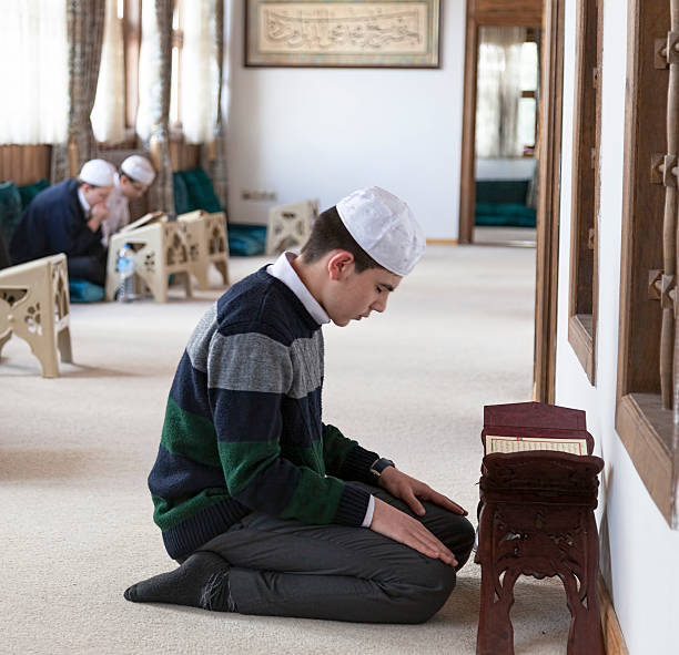 Kid reading The Holy Koran stock photo