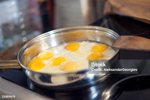 Making Breakfast Cooking Fried Eggs In The Pan Stock Photo - Download Image Now - Black Color, Breakfast, Brown