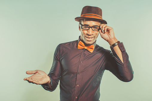 Happy african american male dressed in hipster style, gesturing with hands
