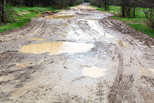 istock puddles on dirty country road in spring 520833540