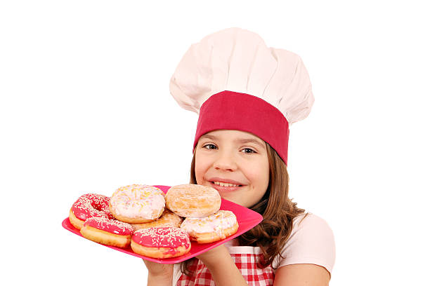 istock little girl cook with donuts on plate 520835202
