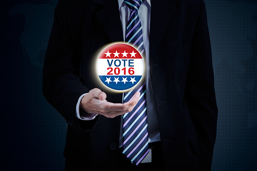 Picture of businessman hand holding a vote symbol with number 2016