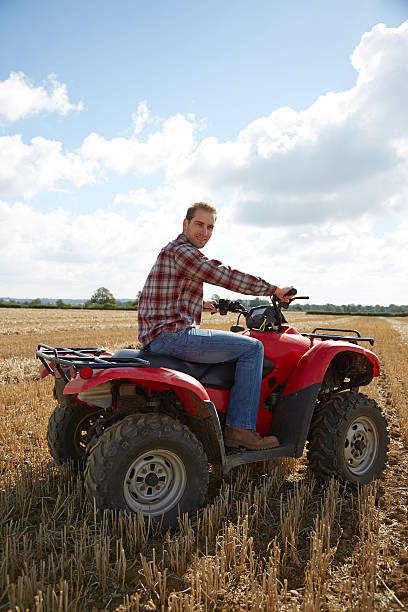 istock Farmer riding an ATV in a field 520840683