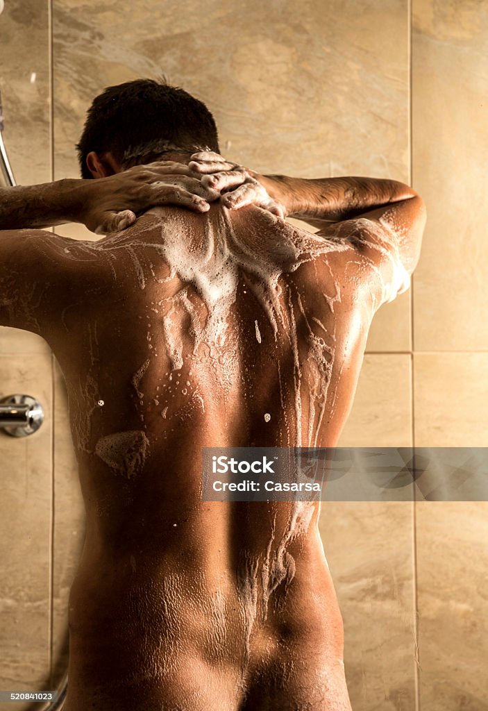 Young man showering Young man showering. rear view. Back Stock Photo