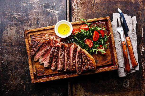 istock Sliced steak and salad with tomatoes and arugula 520842126
