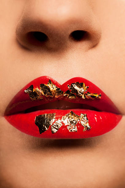 piękne kobiety czerwone usta złoto płatkowe - christmas women human lips female zdjęcia i obrazy z banku zdjęć