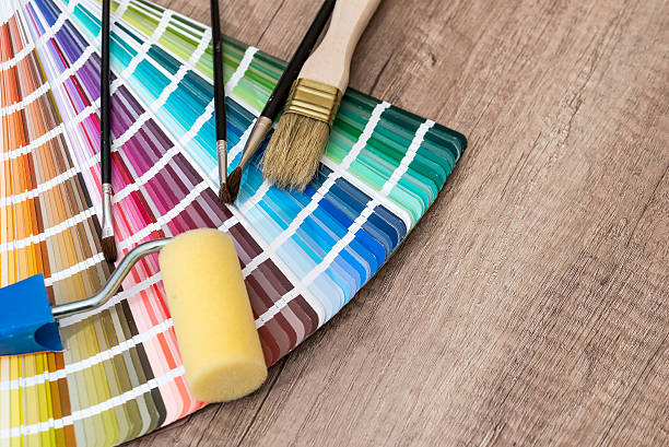 istock Paint roller, brush and color sample catalog on wooden background 520842314