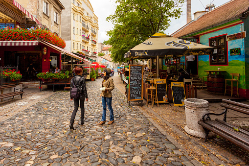 Belgrade, Serbia - July 3, 2014: Women talking in the middle of the street in Skadarlija, a bohemian district, in Belgrade, Serbia. Various restaurants can be seen in the background.