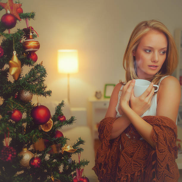 istock Young woman standing near a christmas tree 520843203