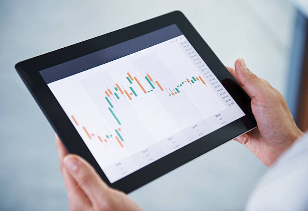 What is our stock doing today? Shot of a digital tablet being held by a businesswoman bar graph photos stock pictures, royalty-free photos & images