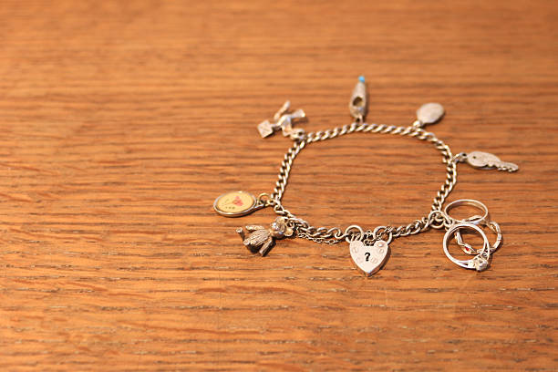 istock Silver charm bracelet on a scratched wooden background 520844033