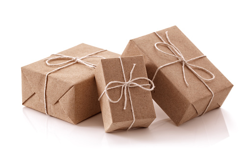 Gift packages wrapped in brown recycled paper isolated on white