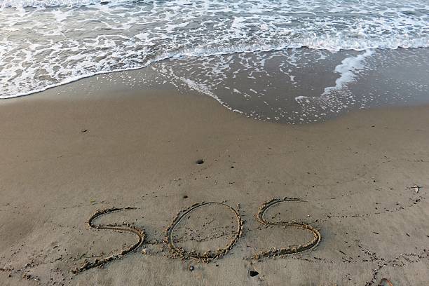 istock S.O.S. written in the sand 520844839